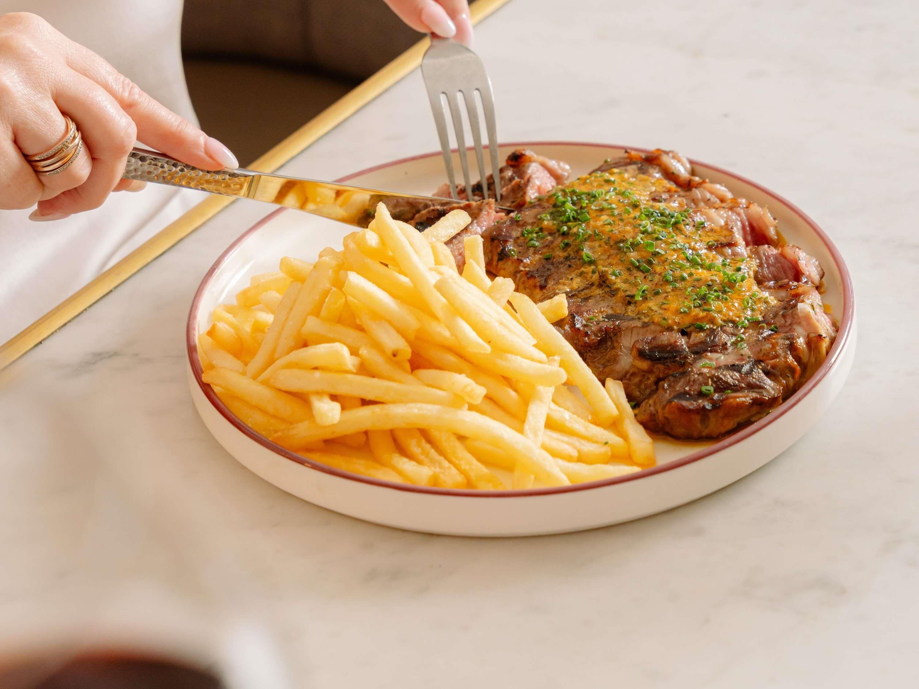 Een bord met steak en friet.