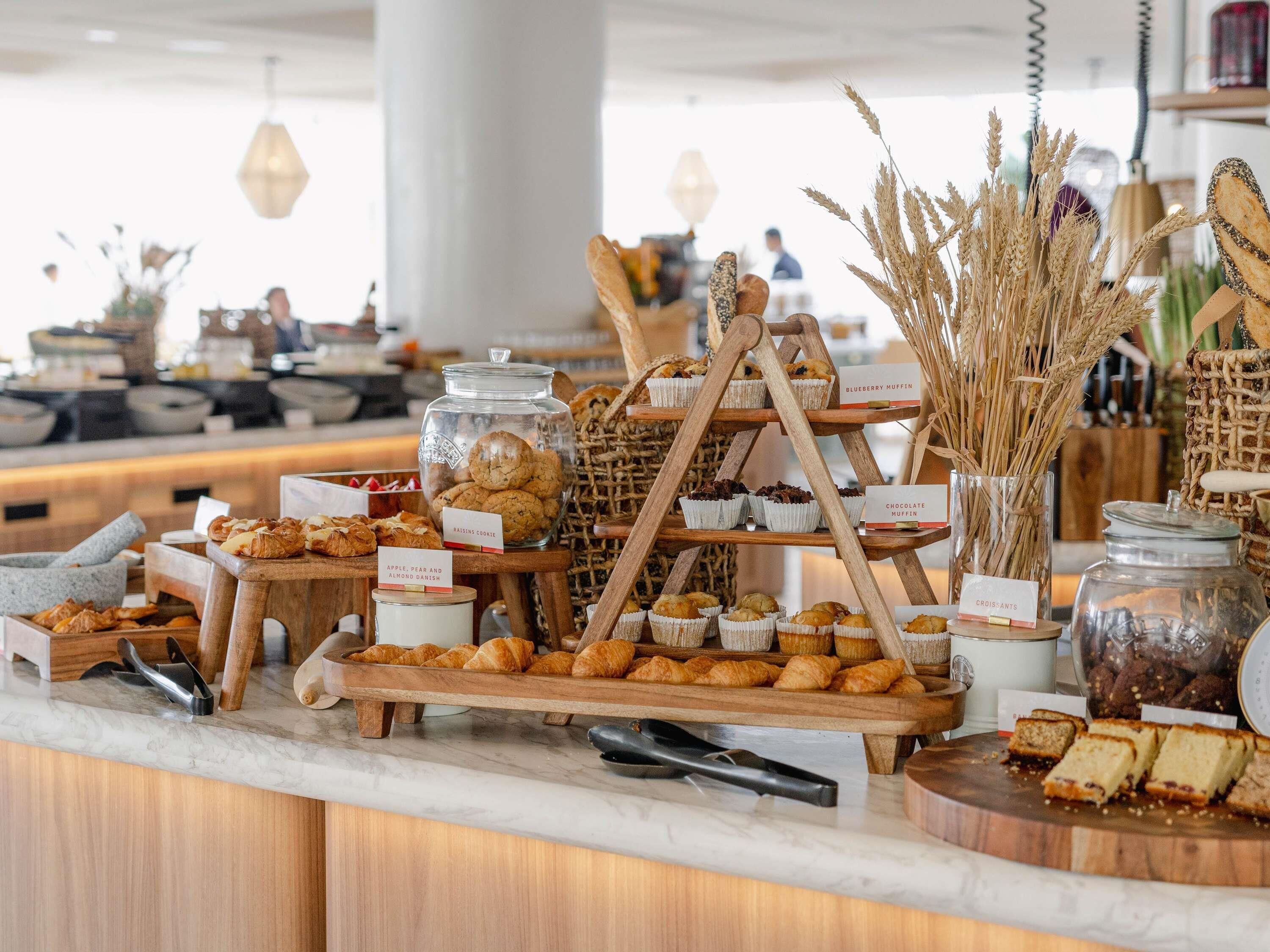 A bakery display with various baked goods and a coffee station.