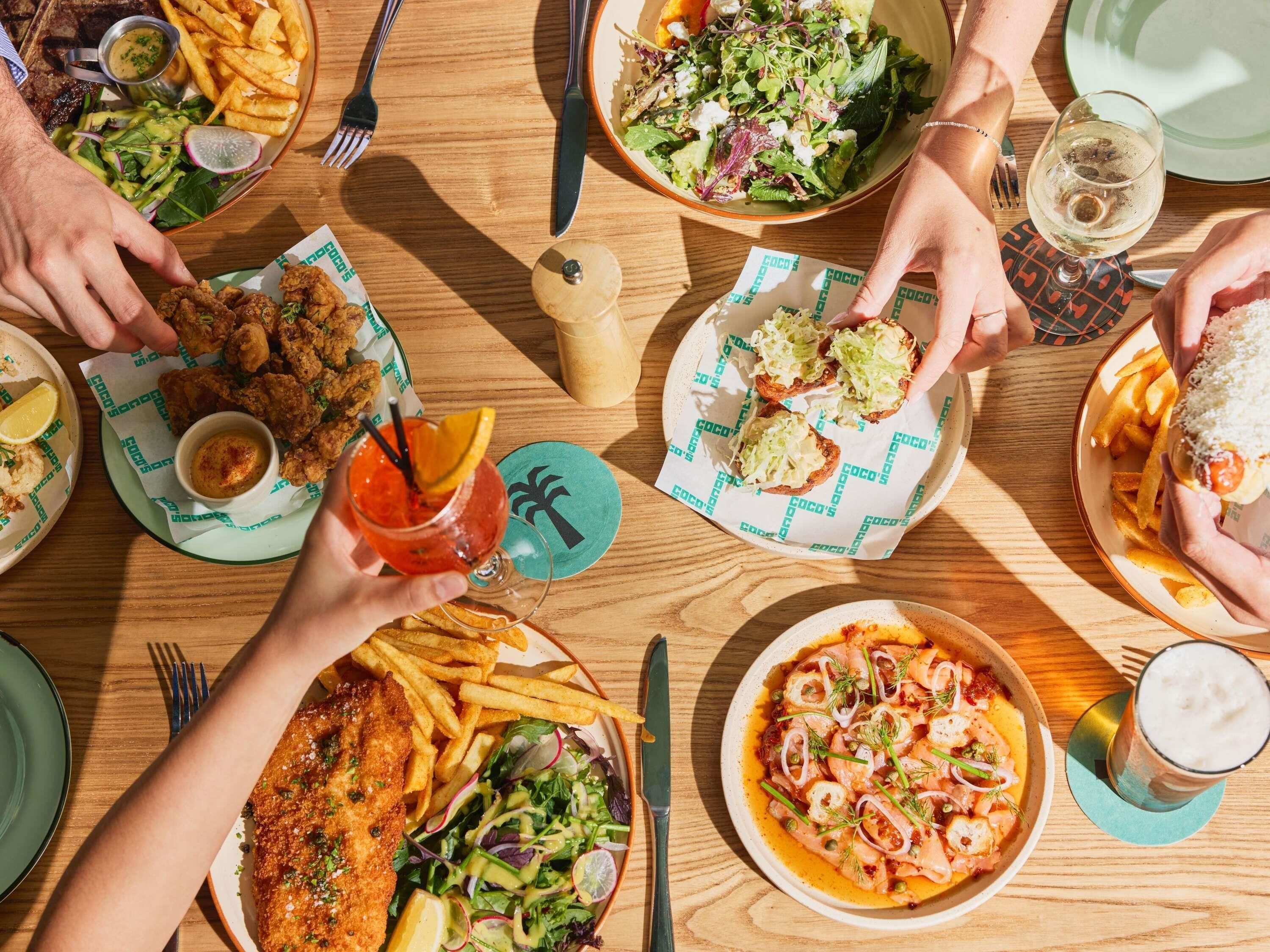 A dining table with various dishes, including seafood, salads, and fried items, suggesting a restaurant setting.