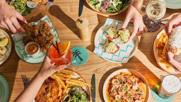 A dining table with various dishes, including seafood, salads, and fried items, suggesting a restaurant setting.