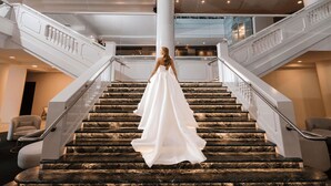 A grand staircase with marble steps and white balustrades, leading to an upper level. - The Brighton Hotel Sydney - MGallery Collection (Brighton-le-Sands)