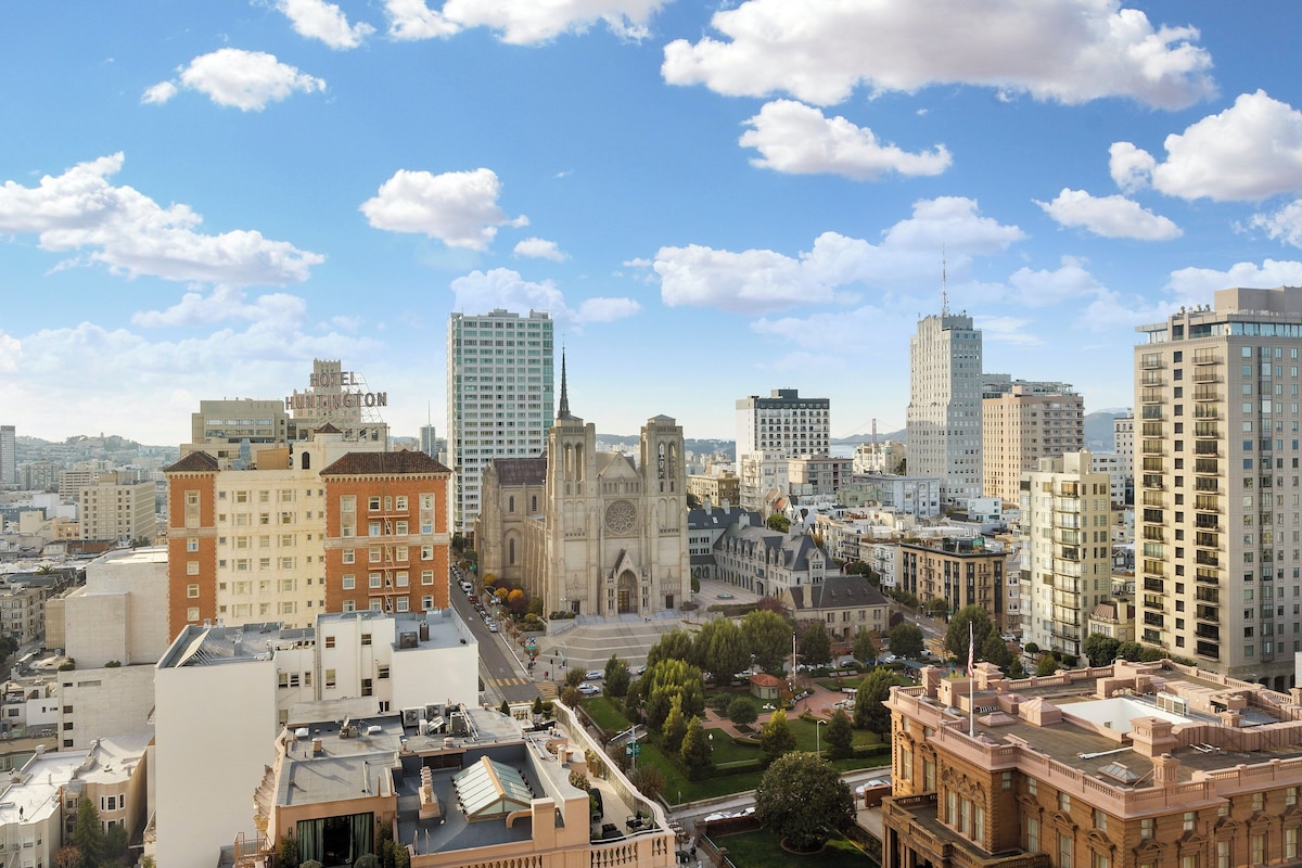 Un paisaje urbano con una iglesia destacada, un hotel y varios edificios altos.