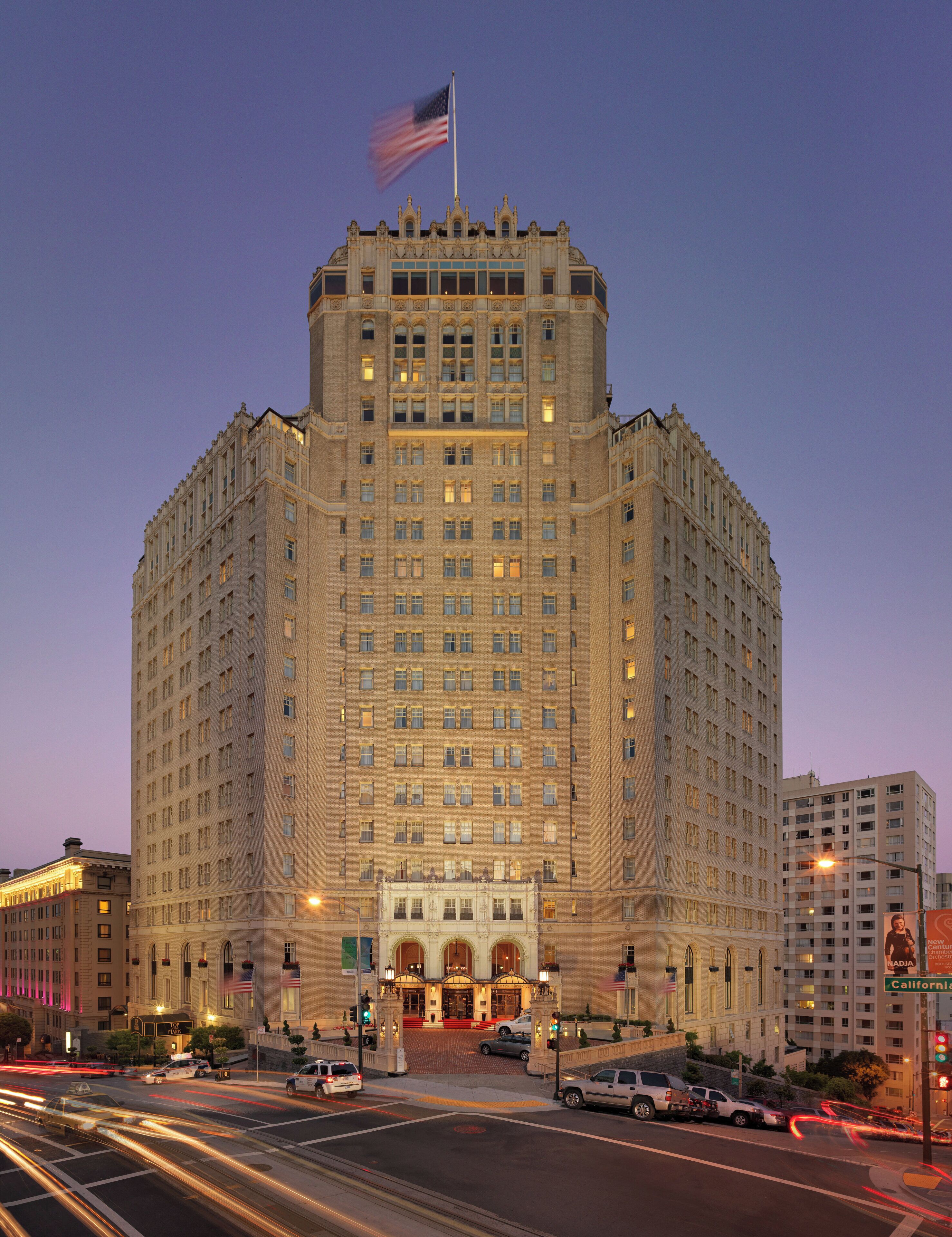 A large, multi-story building with a prominent entrance and flag.