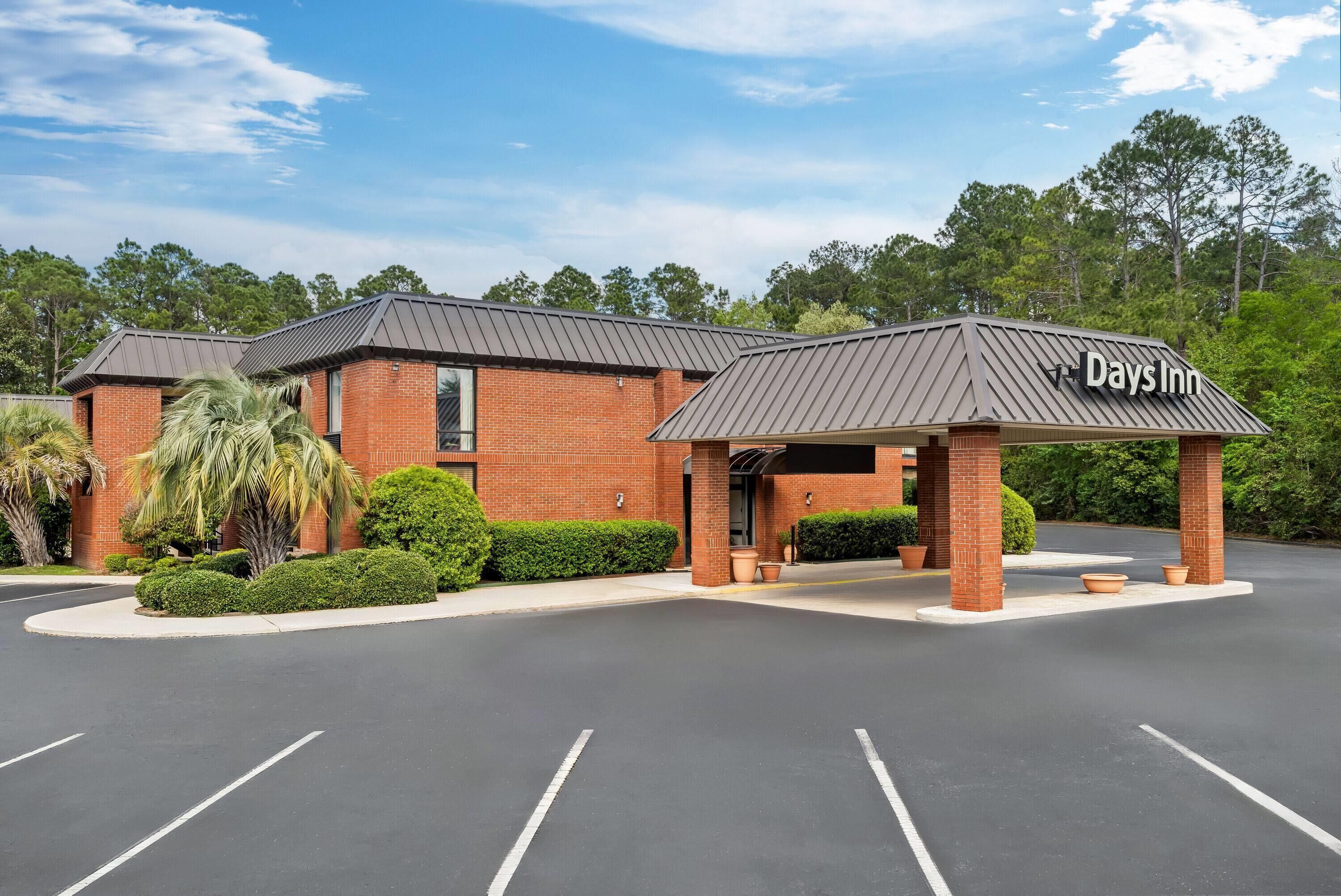 A Days Inn with a brick exterior, a covered entrance, and a parking lot.