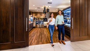 A modern interior with wooden flooring, a kitchen area, and a display case with snacks.