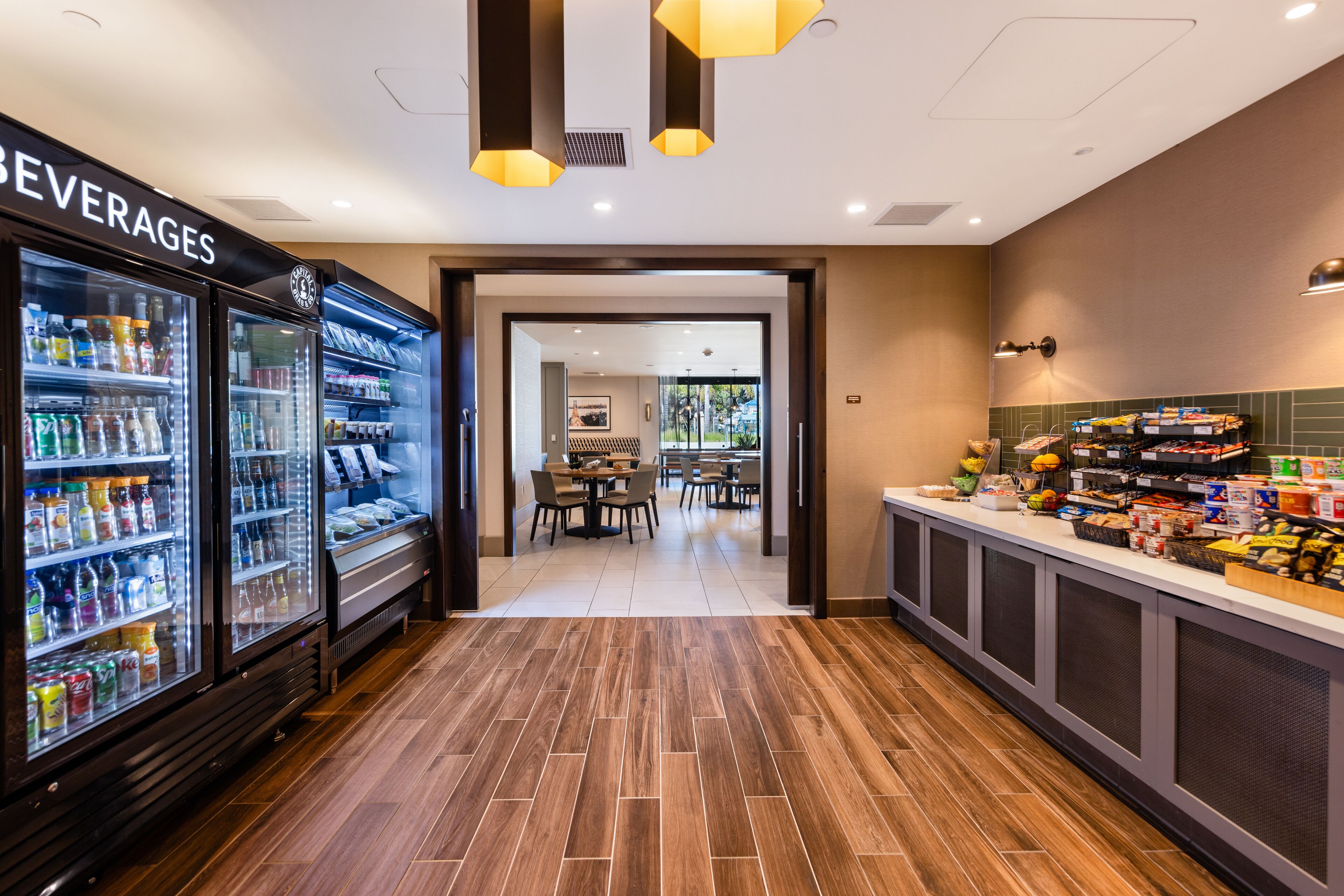 Un hall de hotel con un refrigerador para bebidas, una zona de buffet y un comedor.