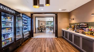 Un hall de hotel con un refrigerador para bebidas, una zona de buffet y un comedor.