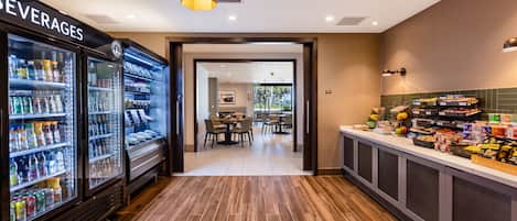 Un hall de hotel con un refrigerador para bebidas, una zona de buffet y un comedor.