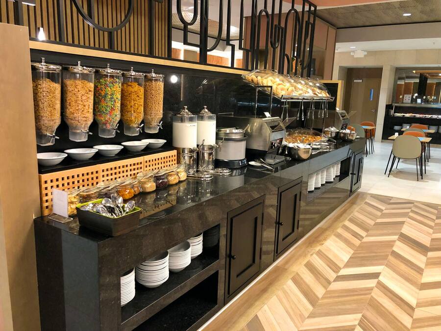 A buffet setup with various food items and utensils.