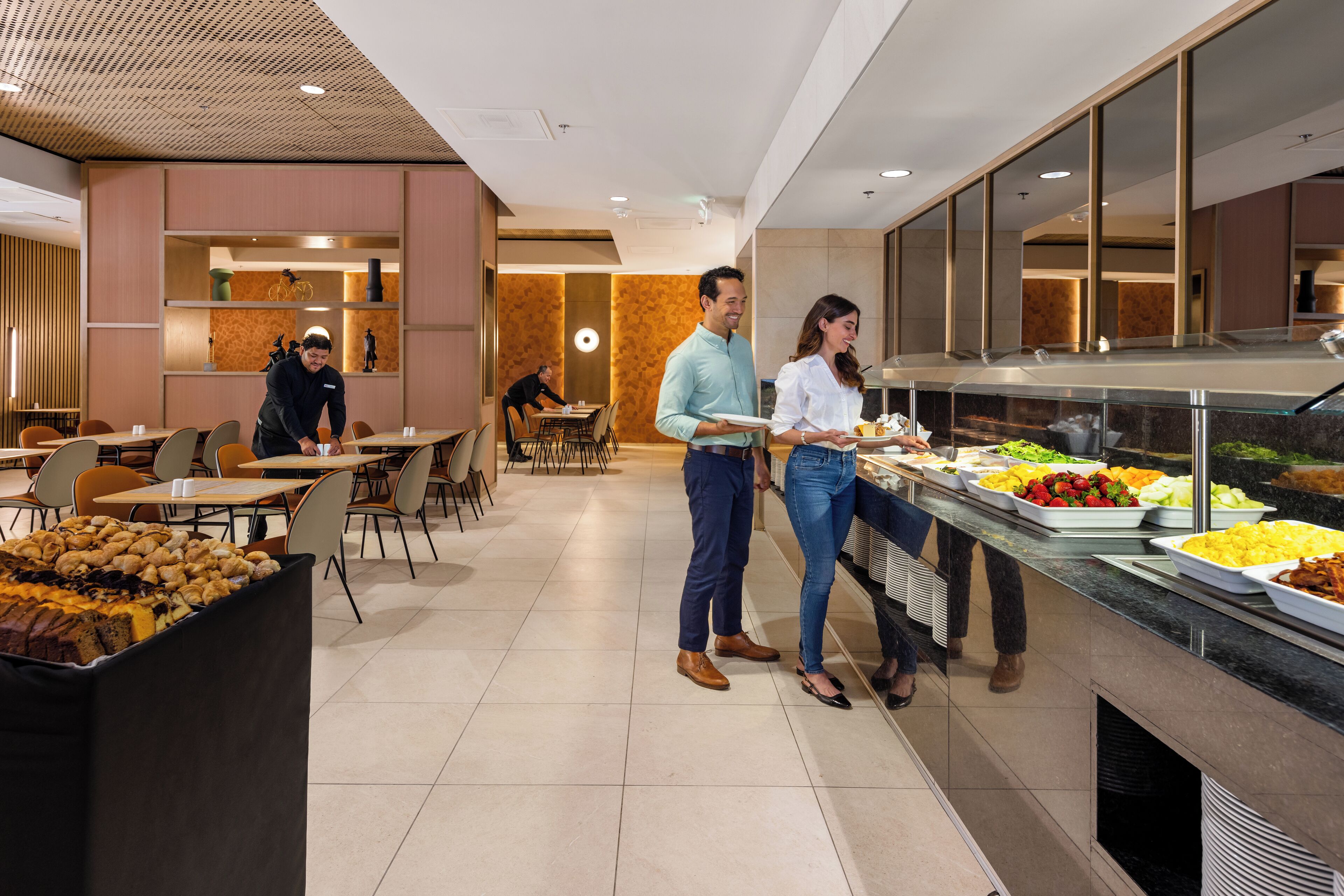 A buffet area with various food options, a seating area with tables and chairs, and a modern interior design.