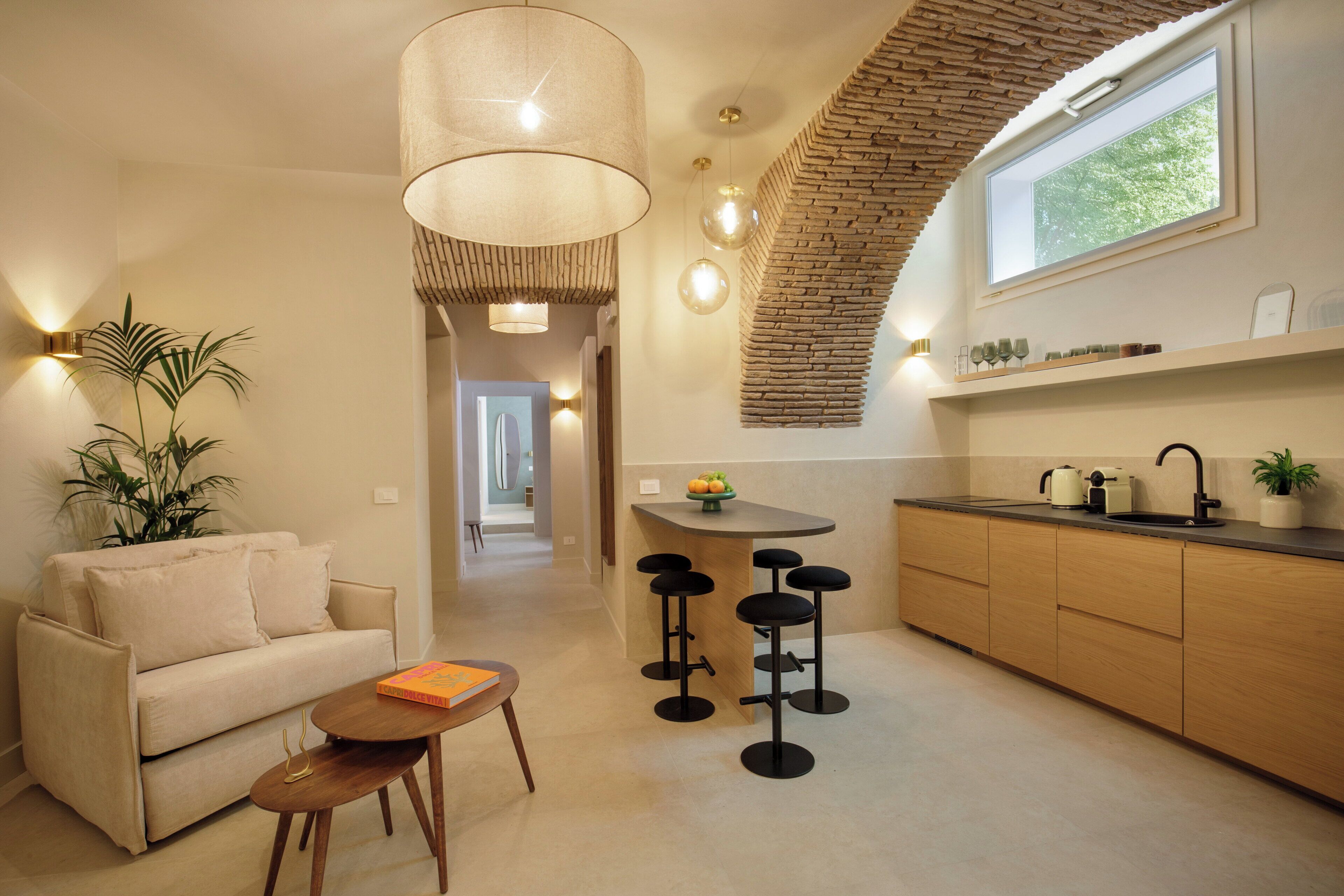 Une cuisine moderne avec un coin bar, une table à manger et un canapé dans un espace de vie lumineux.