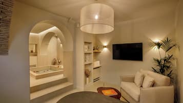A modern living room with a beige sofa, a coffee table, and a TV mounted on the wall.