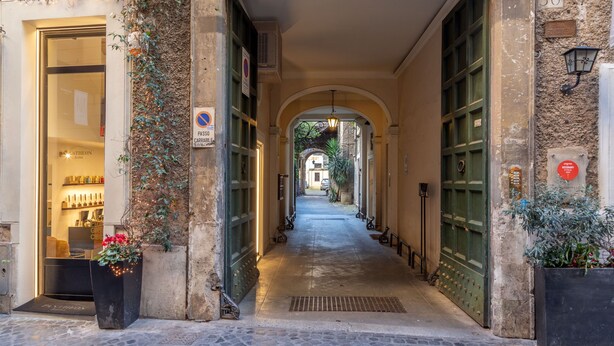 Une ruelle étroite, avec une boutique sur la gauche et une porte sur la droite.