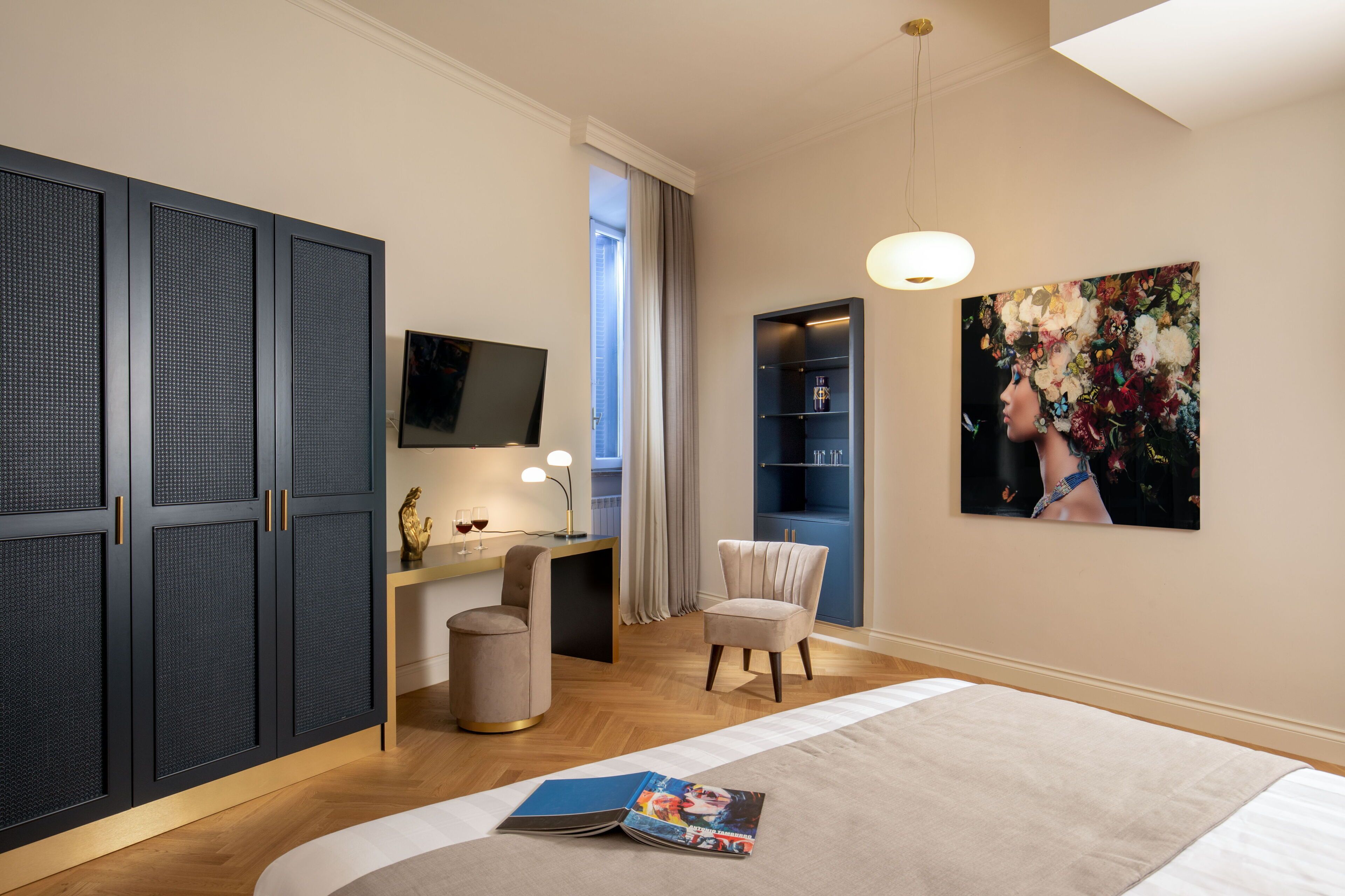 Une chambre moderne avec un grand lit, un bureau avec un ordinateur, une chaise et un téléviseur.