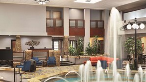 A spacious lobby with a central fountain, seating areas, and a reception desk. - Radisson Hotel Fort Worth North-Fossil Creek (Fort Worth)