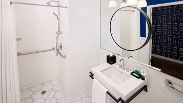 A modern bathroom with a shower, a sink, and a mirror.