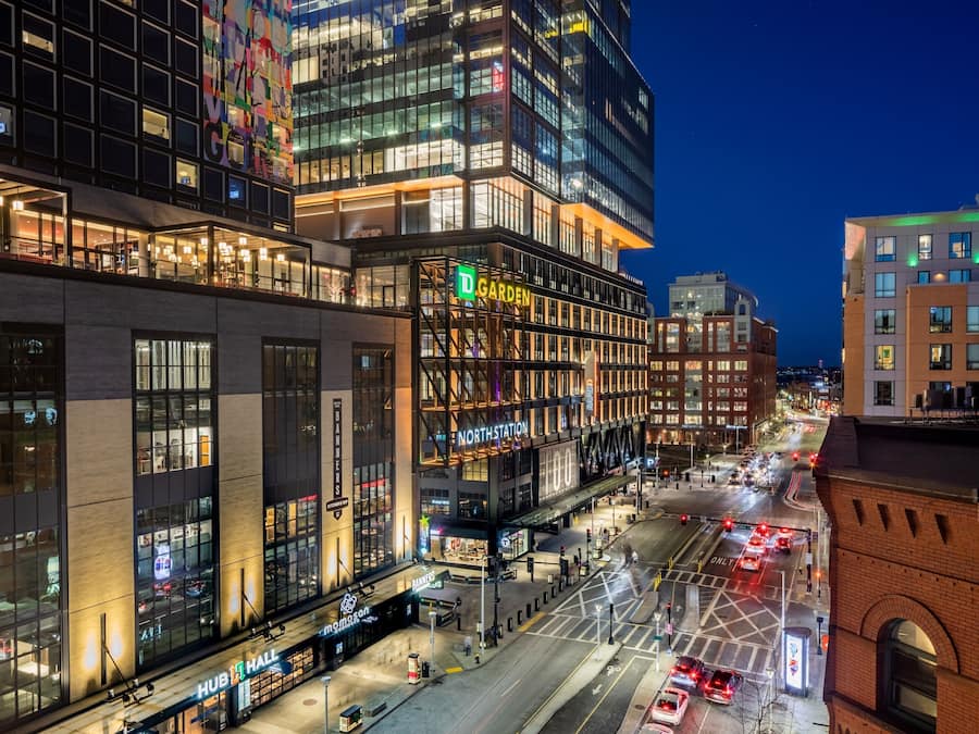 Un edificio de varios pisos con un llamativo letrero que dice 'D GARDEN', un letrero 'NORTHSTATION' y un letrero 'HUB HALL'.