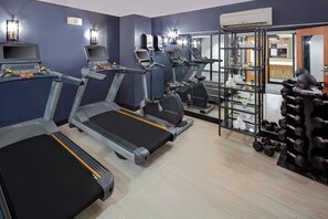 A gym with treadmills, exercise bikes, and a rack of dumbbells. - Hotel Indigo Boston Garden by IHG (Boston)