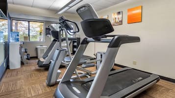 A gym with treadmills, water coolers, and exercise equipment.