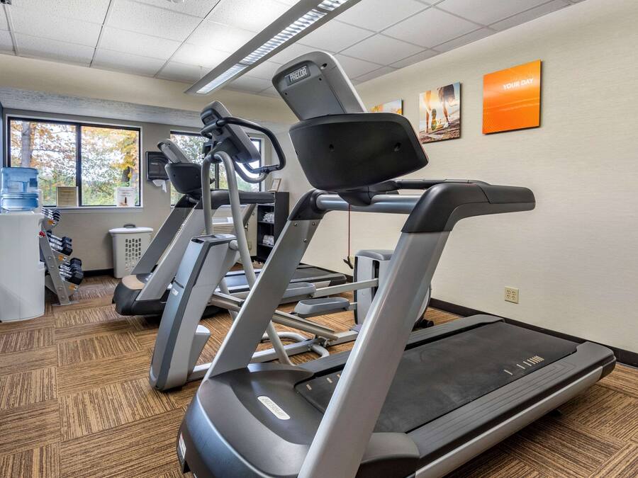 A gym with treadmills, water coolers, and exercise equipment.