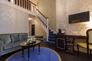 A living room with a sofa, coffee table, and a staircase leading to another level.