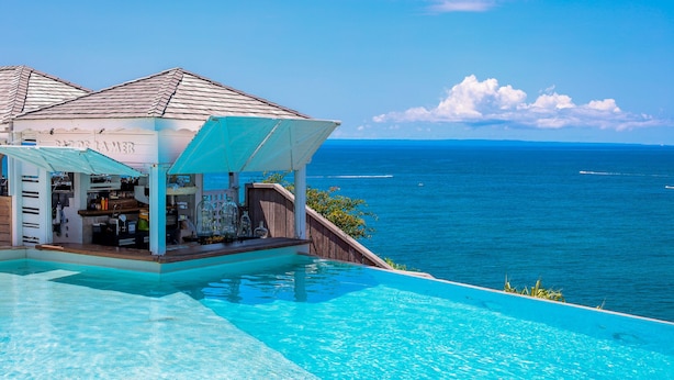 A infinity pool with a bar area overlooking the ocean. - La Toubana Hôtel & Spa (Sainte-Anne)