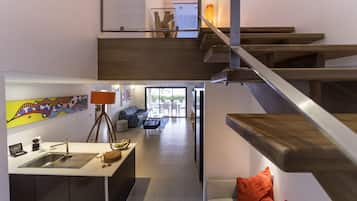 Una cocina moderna con un lavaplatos integrado y una zona de comedor con mesa y sillas.
