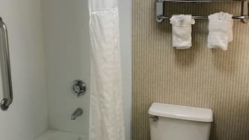 Un baño con ducha, inodoro y toallero.