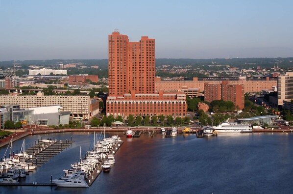 A marina with boats docked, a large red building, and a cityscape in the background. - The Royal Sonesta Harbor Court Baltimore (Baltimore)