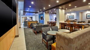A hotel lobby with seating areas, a reception desk, and a bar. - Holiday Inn Express Richmond - Midtown by IHG (Richmond)