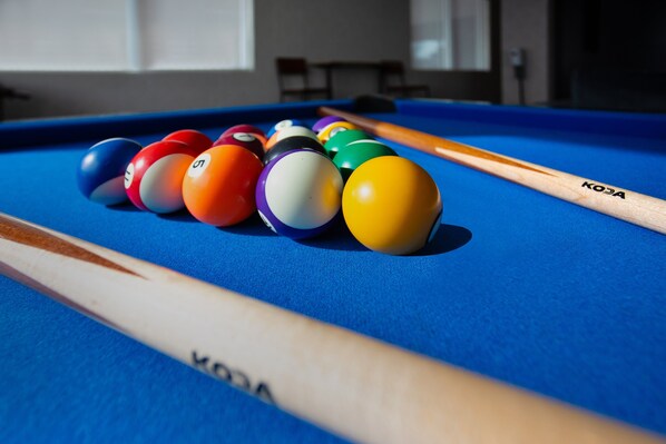 A pool table with a blue felt surface and a wooden pool cue. - Holiday Inn Express Richmond - Midtown by IHG (Richmond)