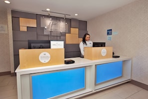 A hotel reception desk with a modern design, featuring a digital display and a sign indicating the hotel name. - Holiday Inn Express Richmond - Midtown by IHG (Richmond)