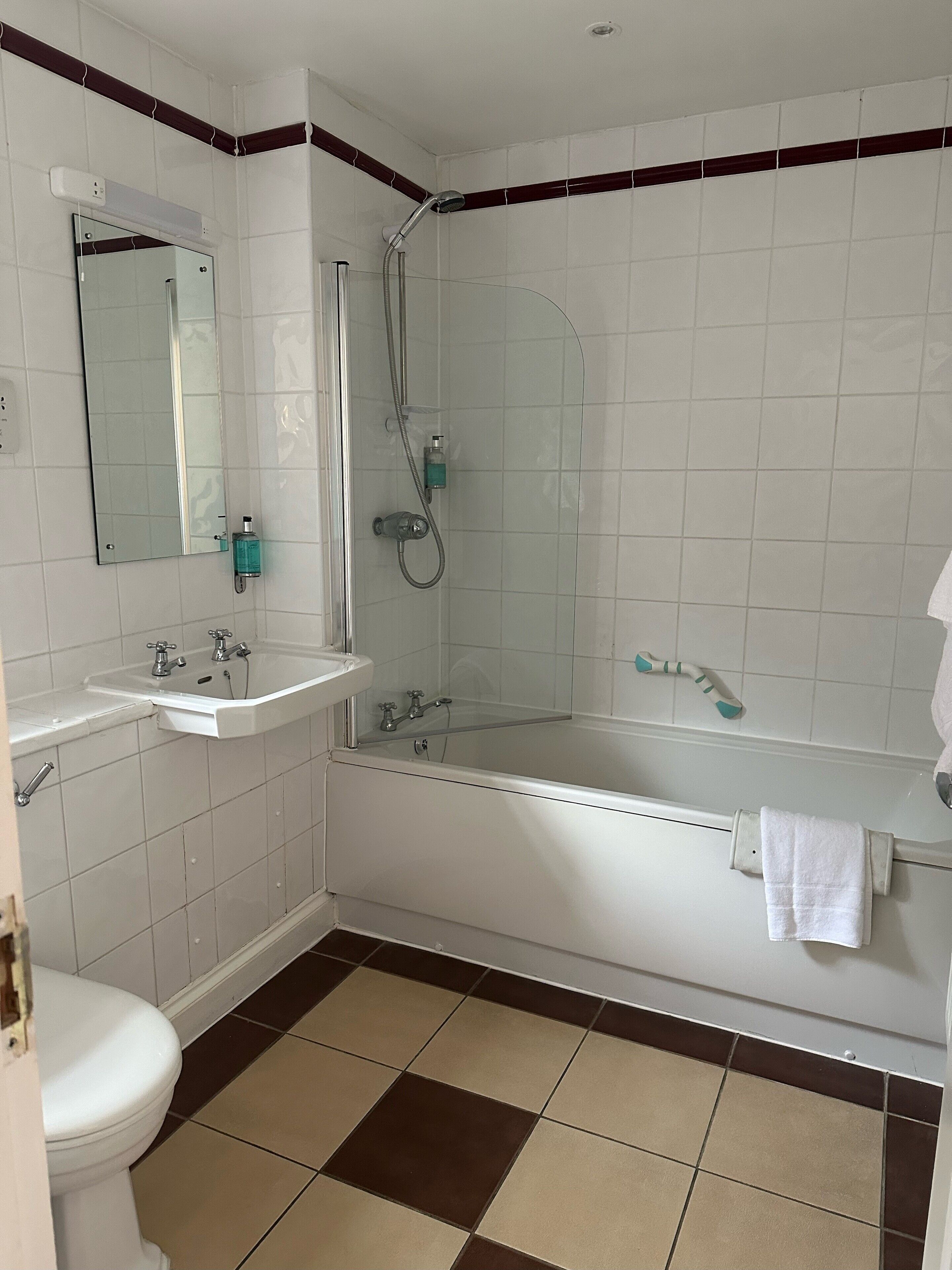 A bathroom with a toilet, two sinks, a bathtub, and a shower.