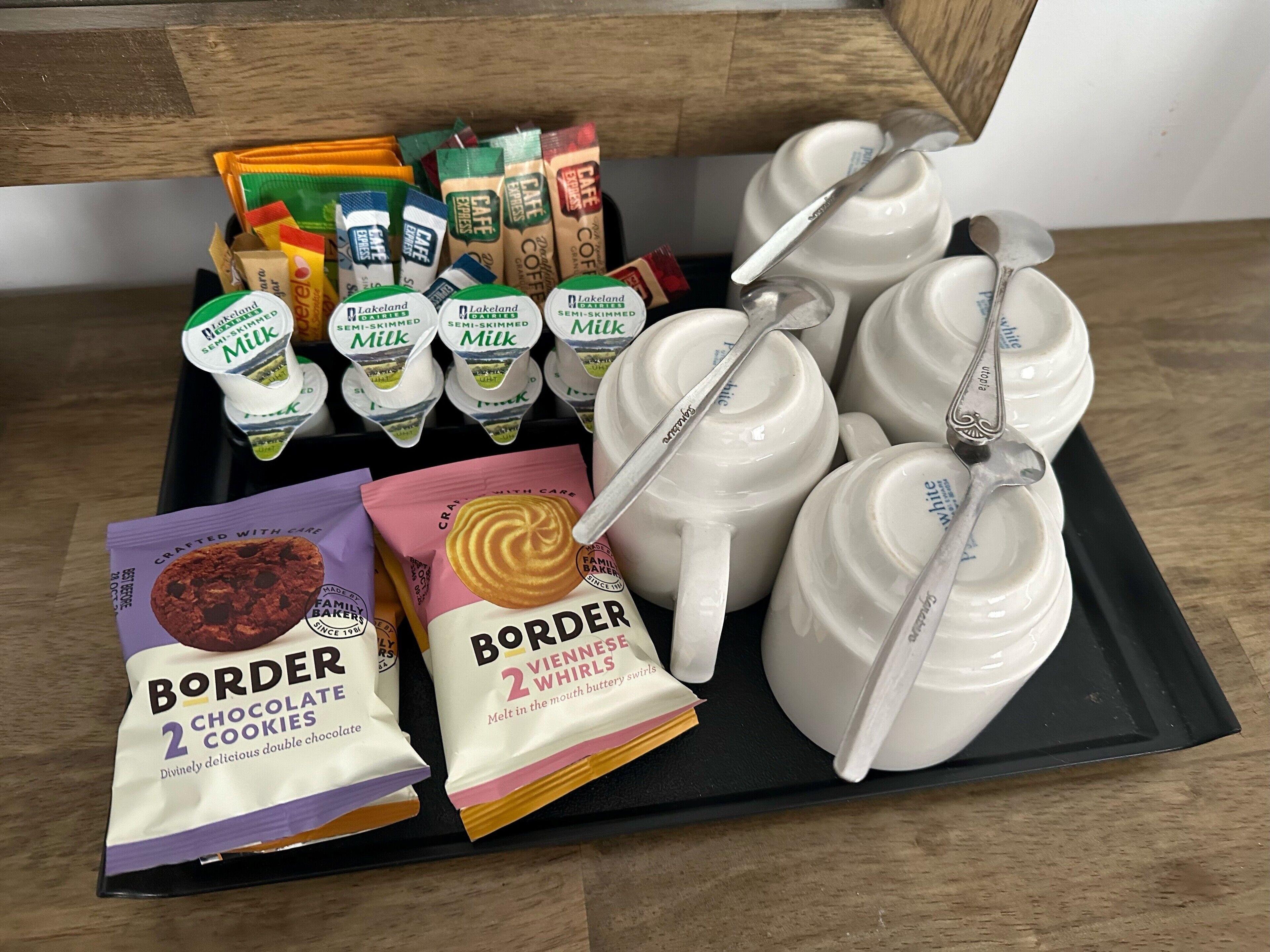 A tray with various food items including cookies, milk, and coffee.