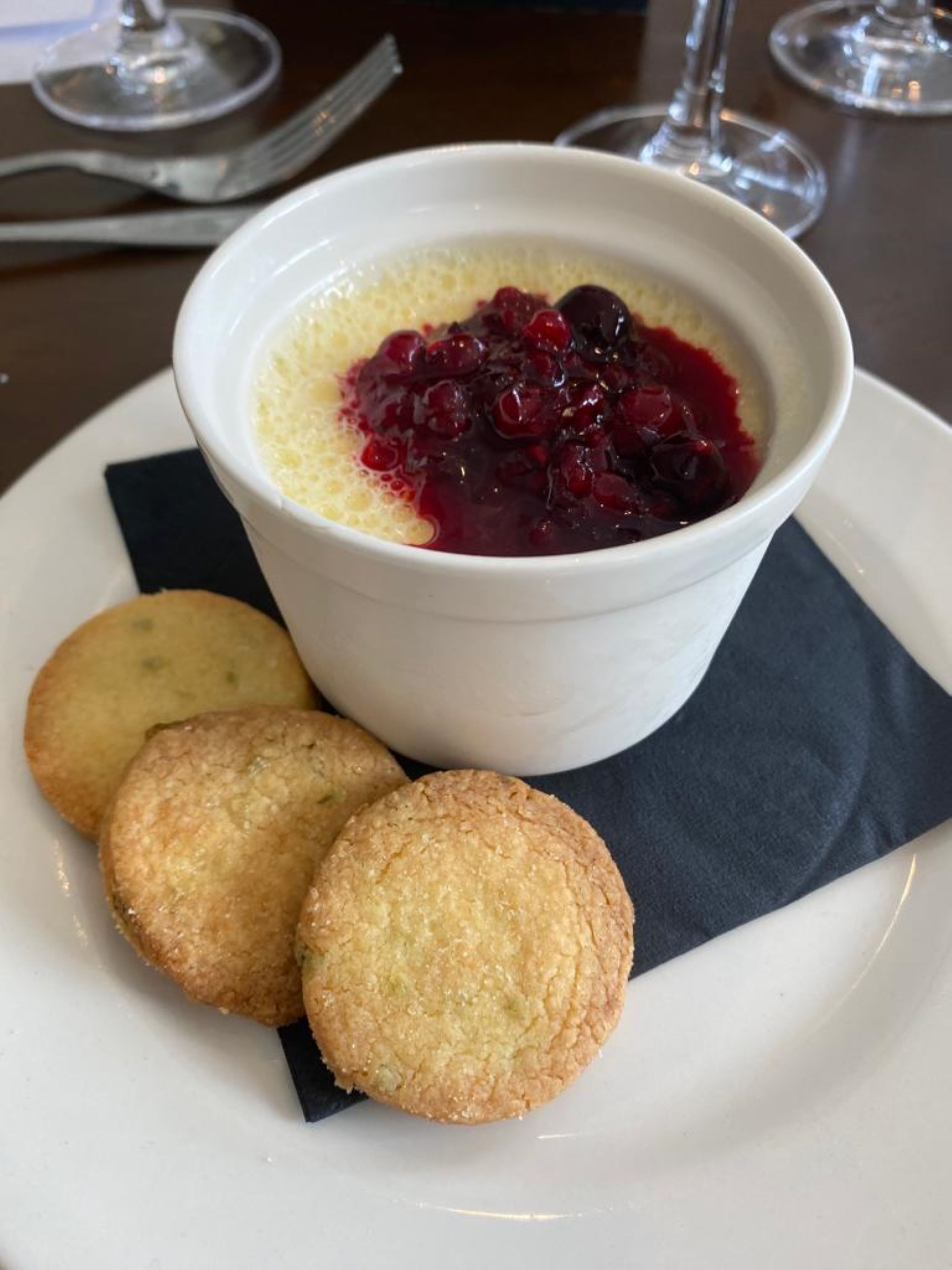 A dessert with berries and biscuits on a plate.