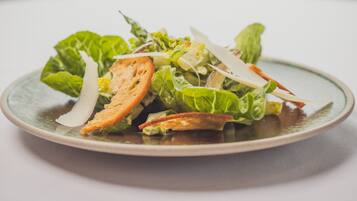 A plate of salad with greens and croutons.