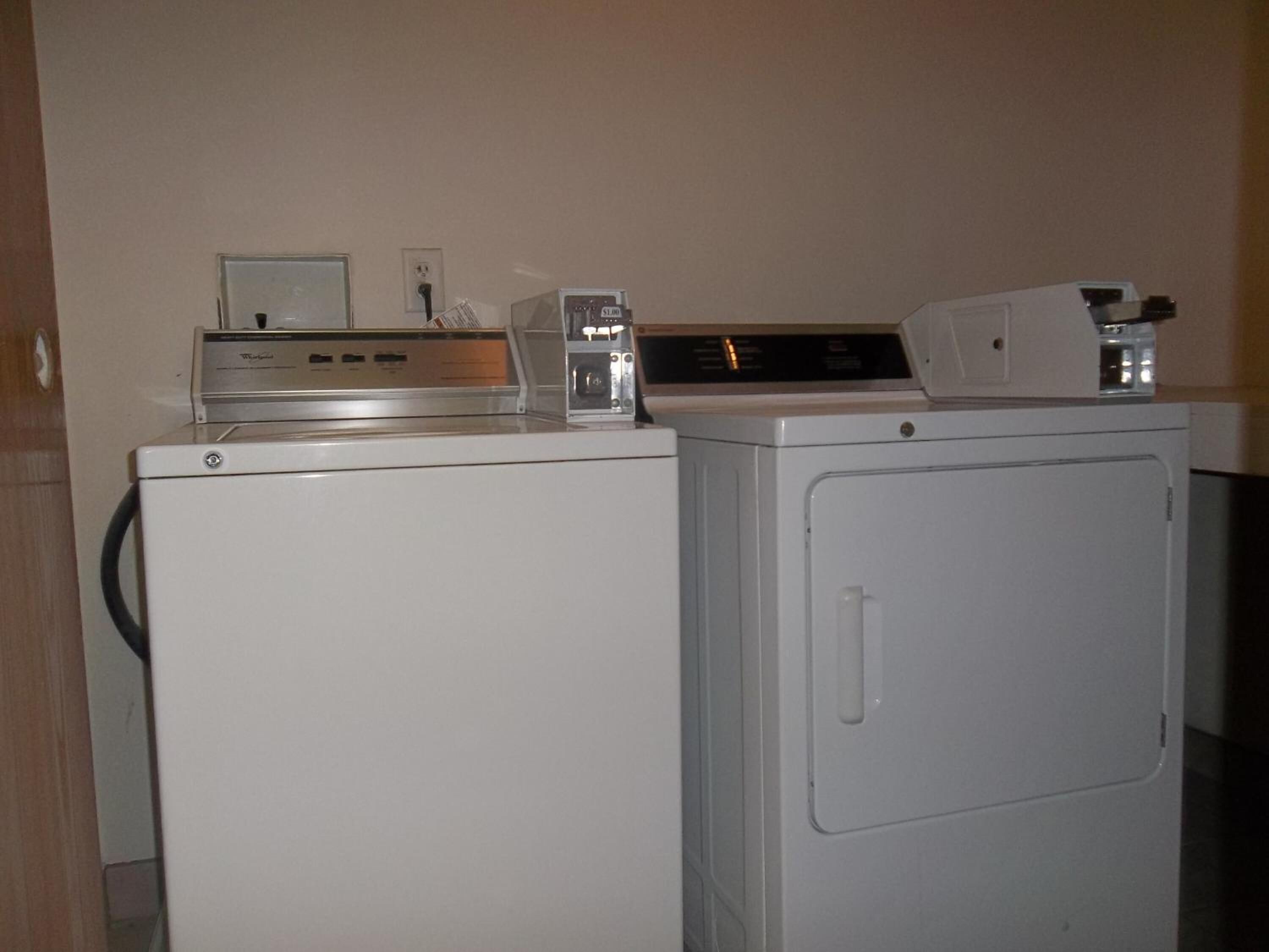 A laundry area with a front-loading washer and a stacked dryer.