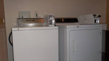 A laundry area with a front-loading washer and a stacked dryer.