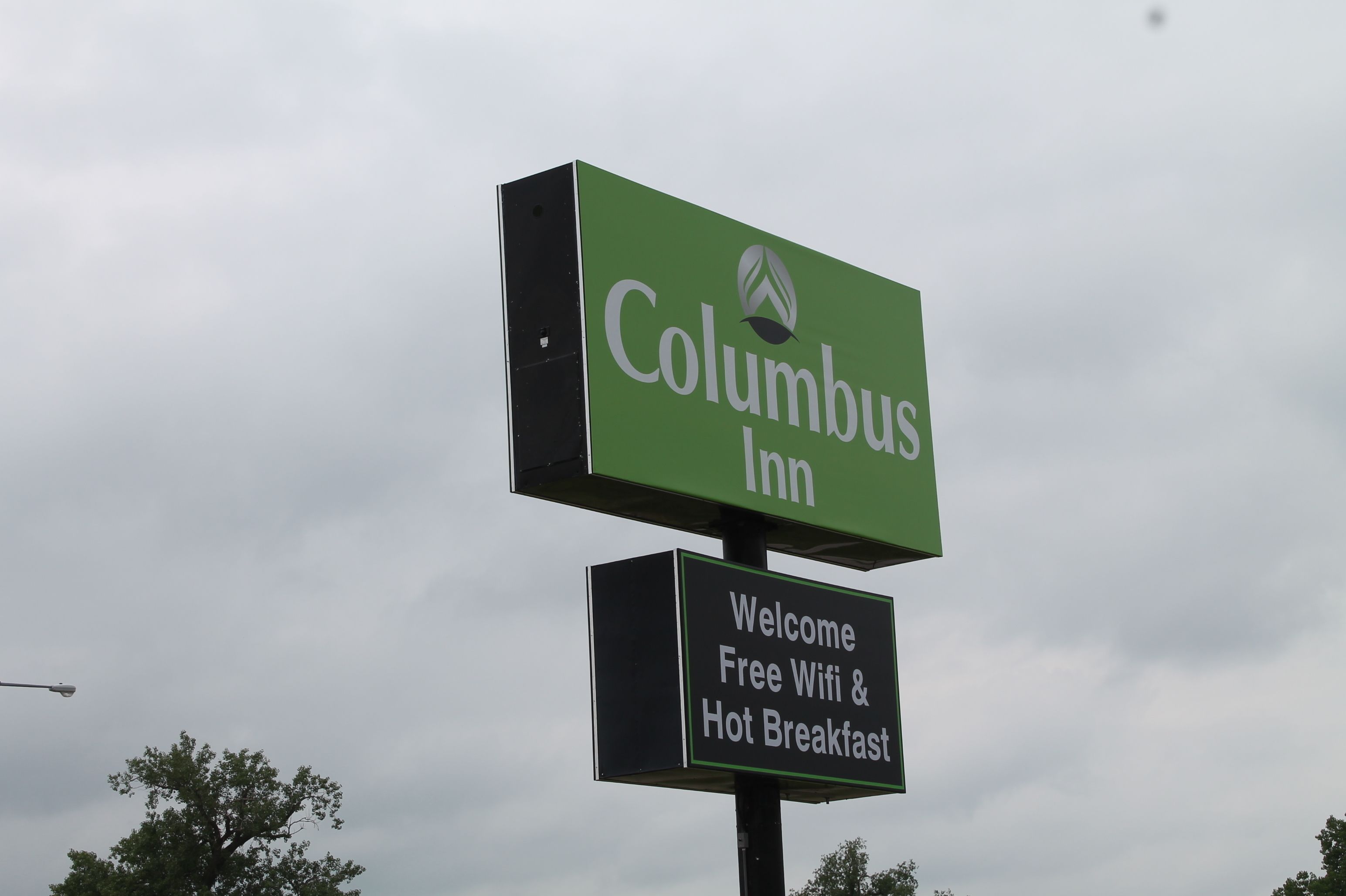 A Columbus Inn sign with a welcome message for free wifi and hot breakfast.