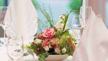 A table set for a meal with a centerpiece of flowers and a candle.