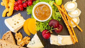 A charcuterie board with various cheeses, fruits, nuts, and crackers.