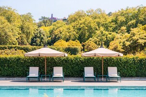 Una piscina al aire libre, sillones reclinables de piscina