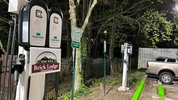 Electric vehicle charging stations, a parking sign, and a brick lodge sign.