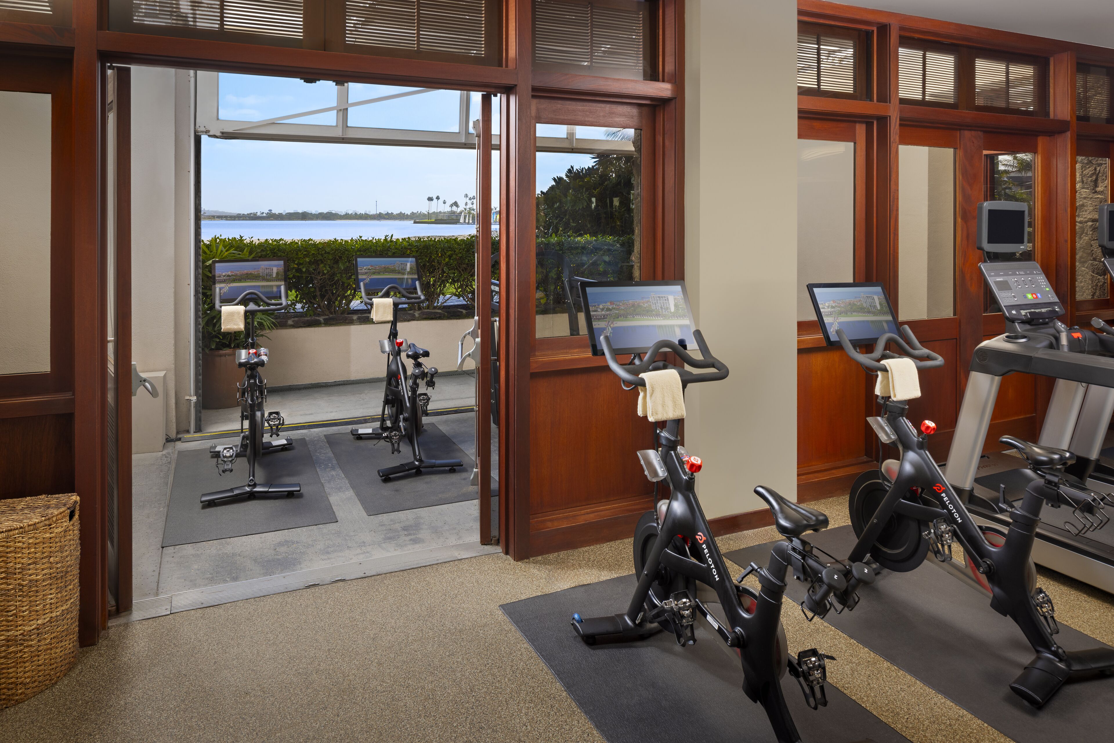 A gym with stationary bikes, treadmills, and exercise mats.