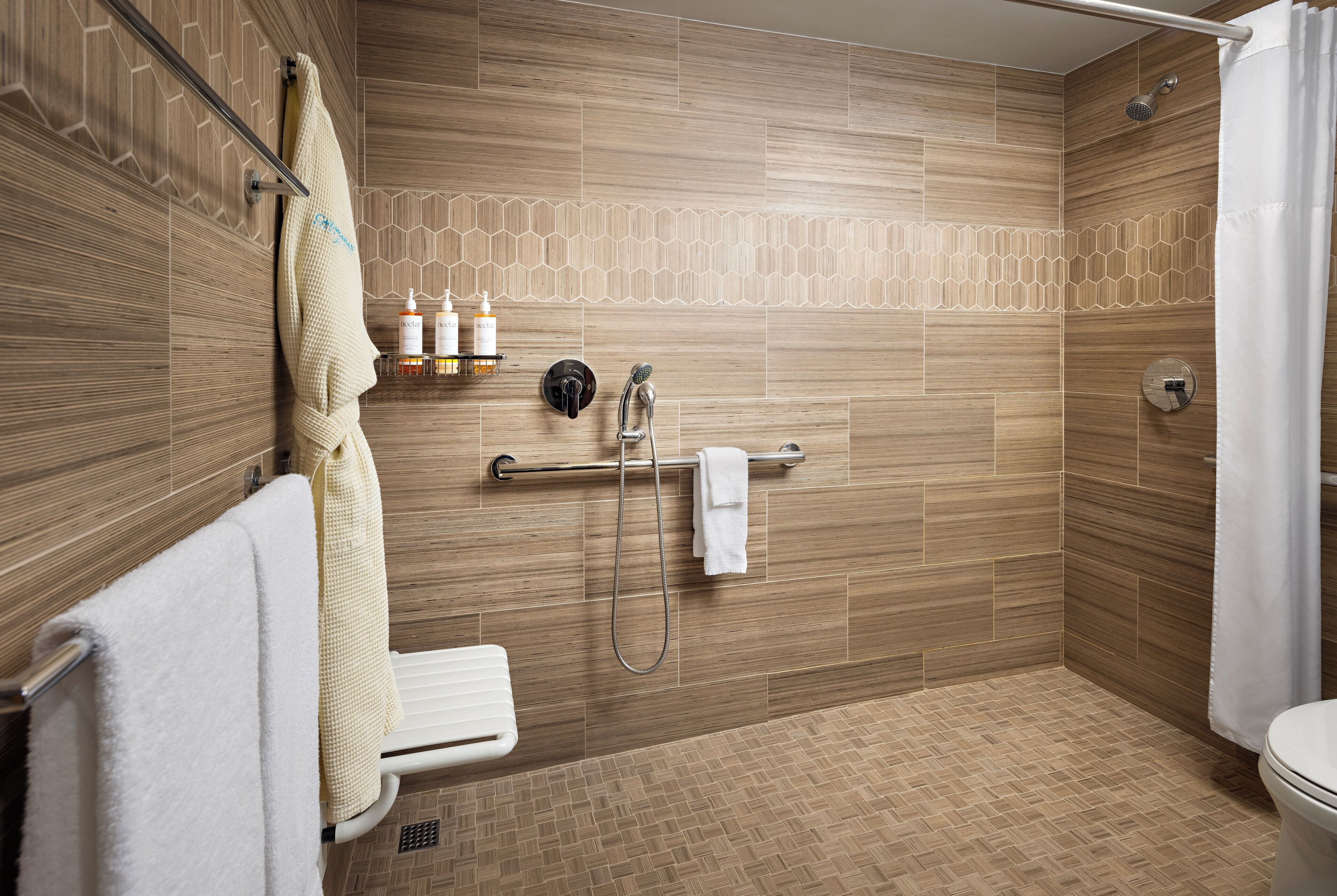 A modern bathroom with a shower, toilet, and towel rack.