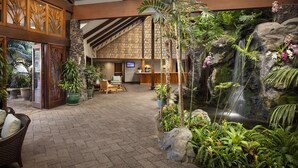 A spacious lobby with a waterfall feature, wooden decor, and comfortable seating areas. - Catamaran Resort and Spa (San Diego)