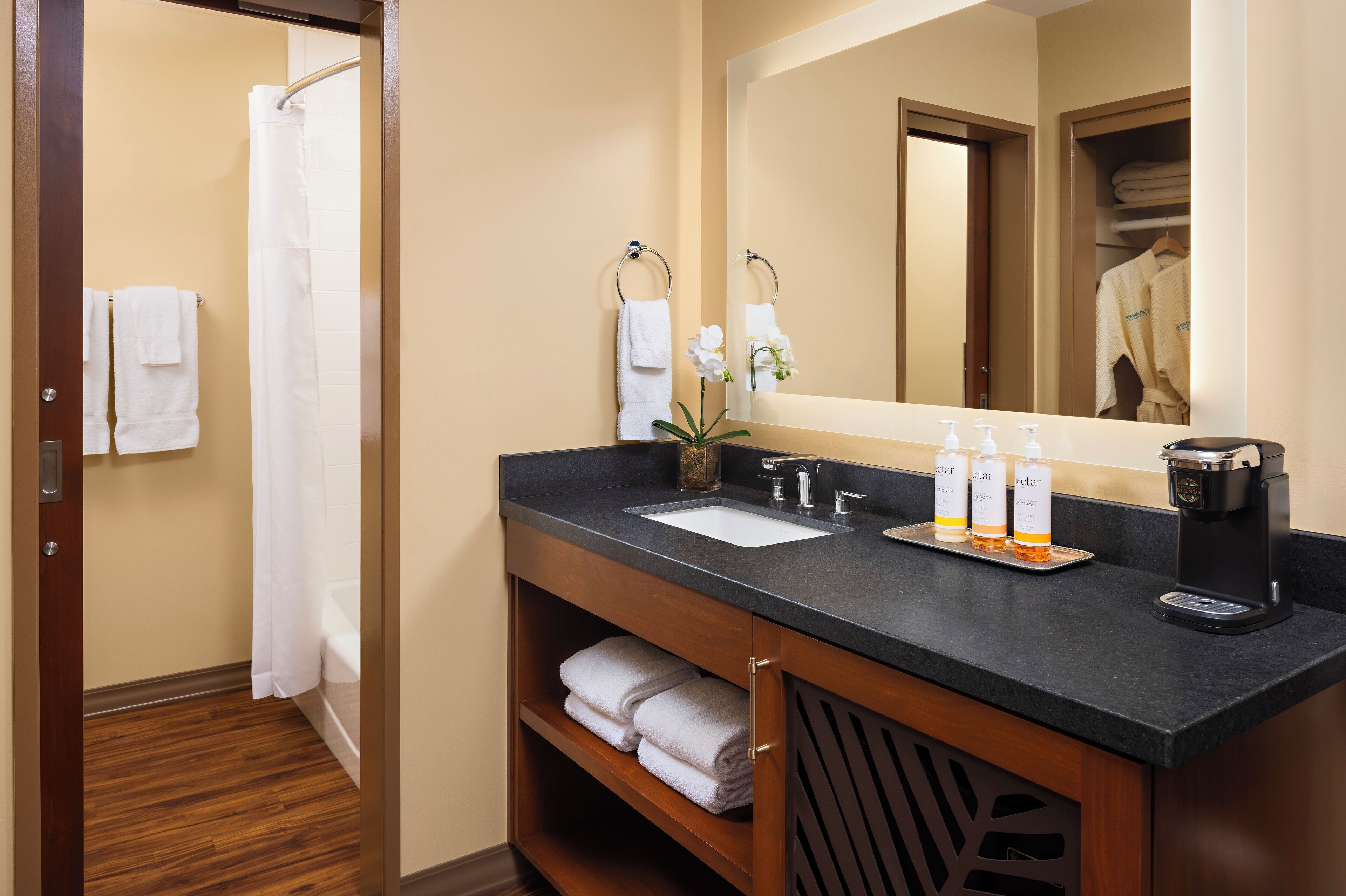 A bathroom with a sink, mirror, and toiletries.