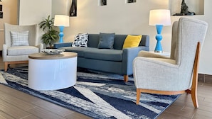 A modern living room with a grey sofa, a round coffee table, and a patterned rug. - Comfort Inn Ocala Silver Springs (Ocala)