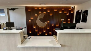 A reception desk with a crescent moon design, a computer, and a security camera. - Comfort Inn Ocala Silver Springs (Ocala)