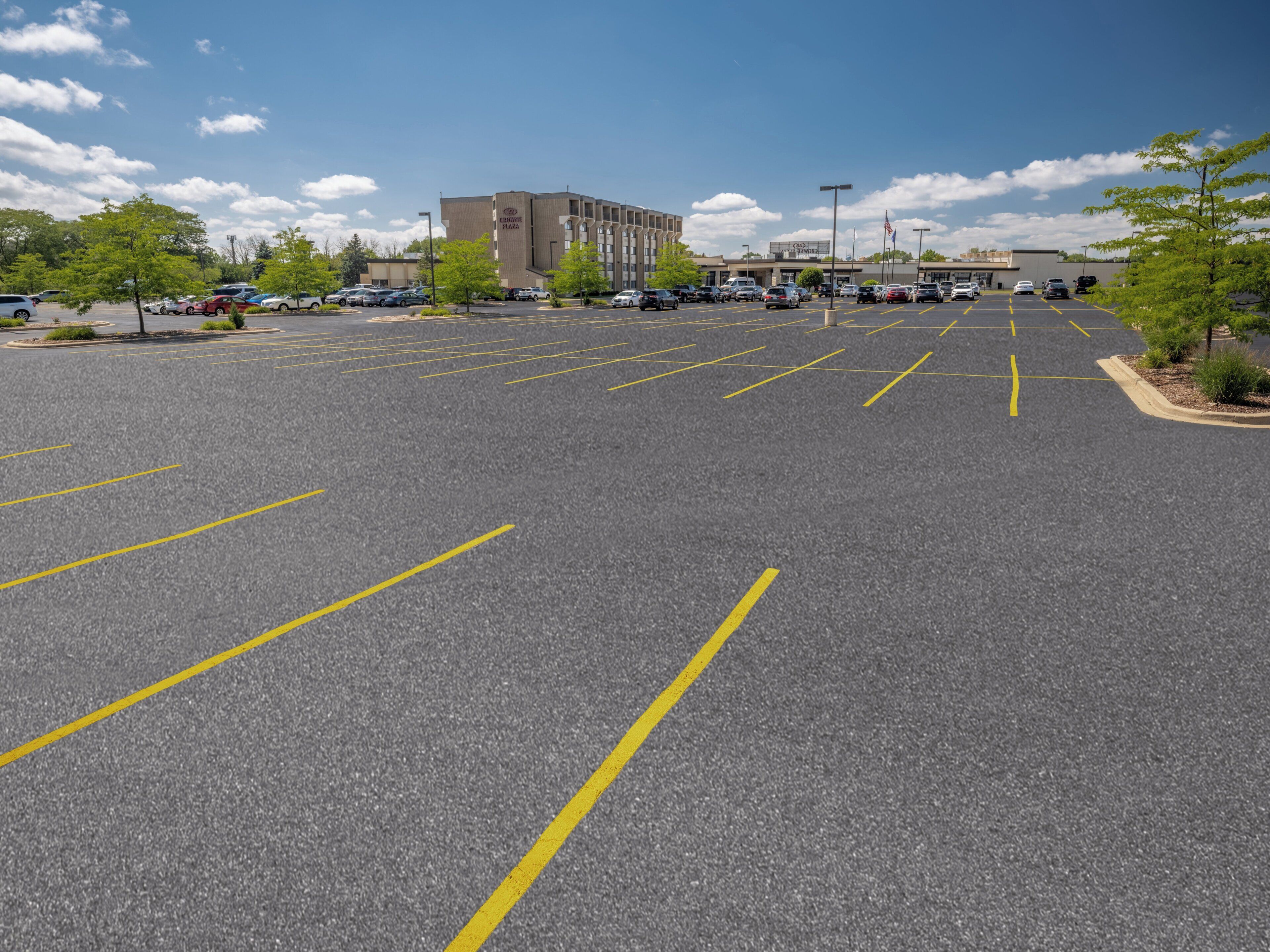 Un parking avec des places délimitées et un bâtiment en arrière-plan.